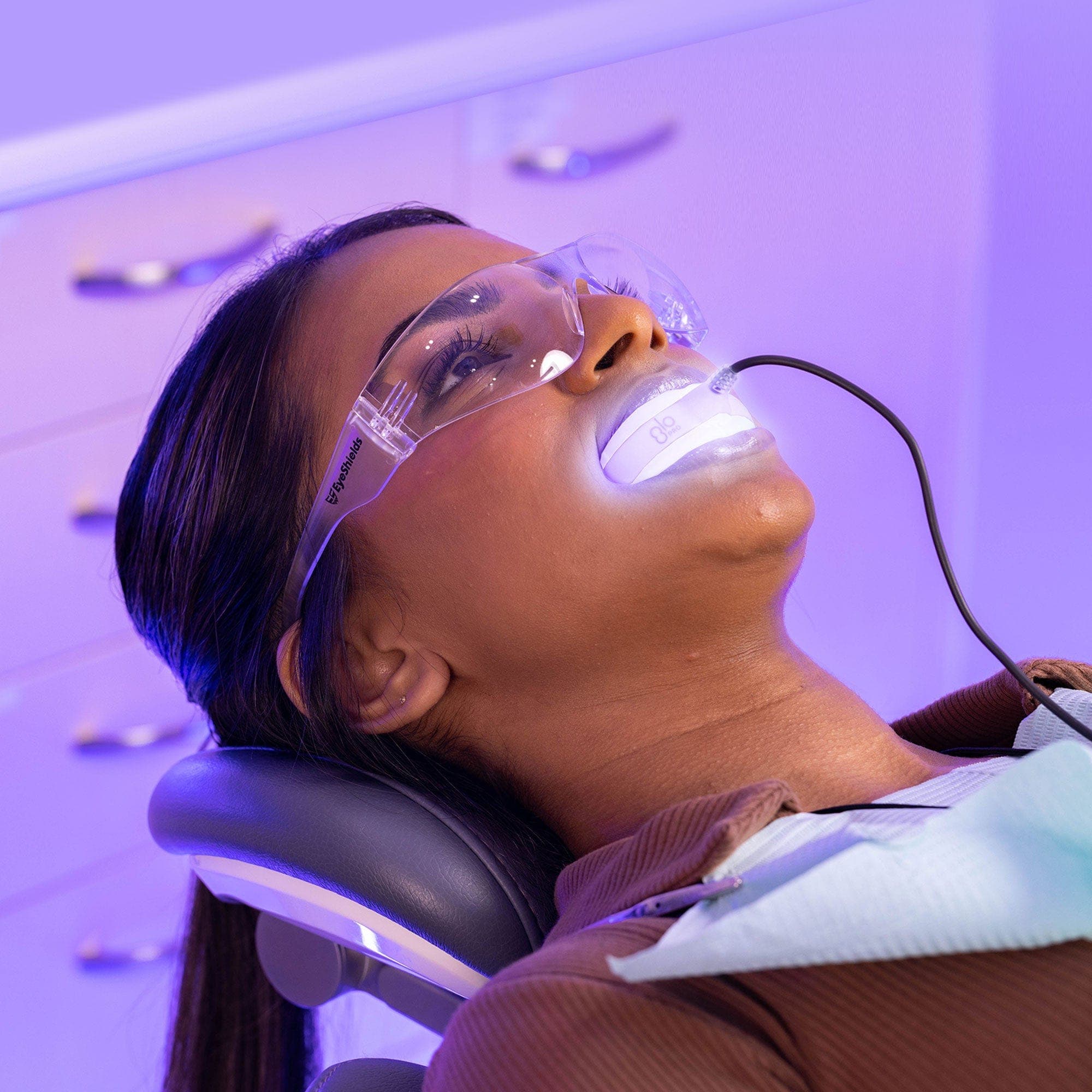 GLO Science model reclined with the lit mouthpiece in place